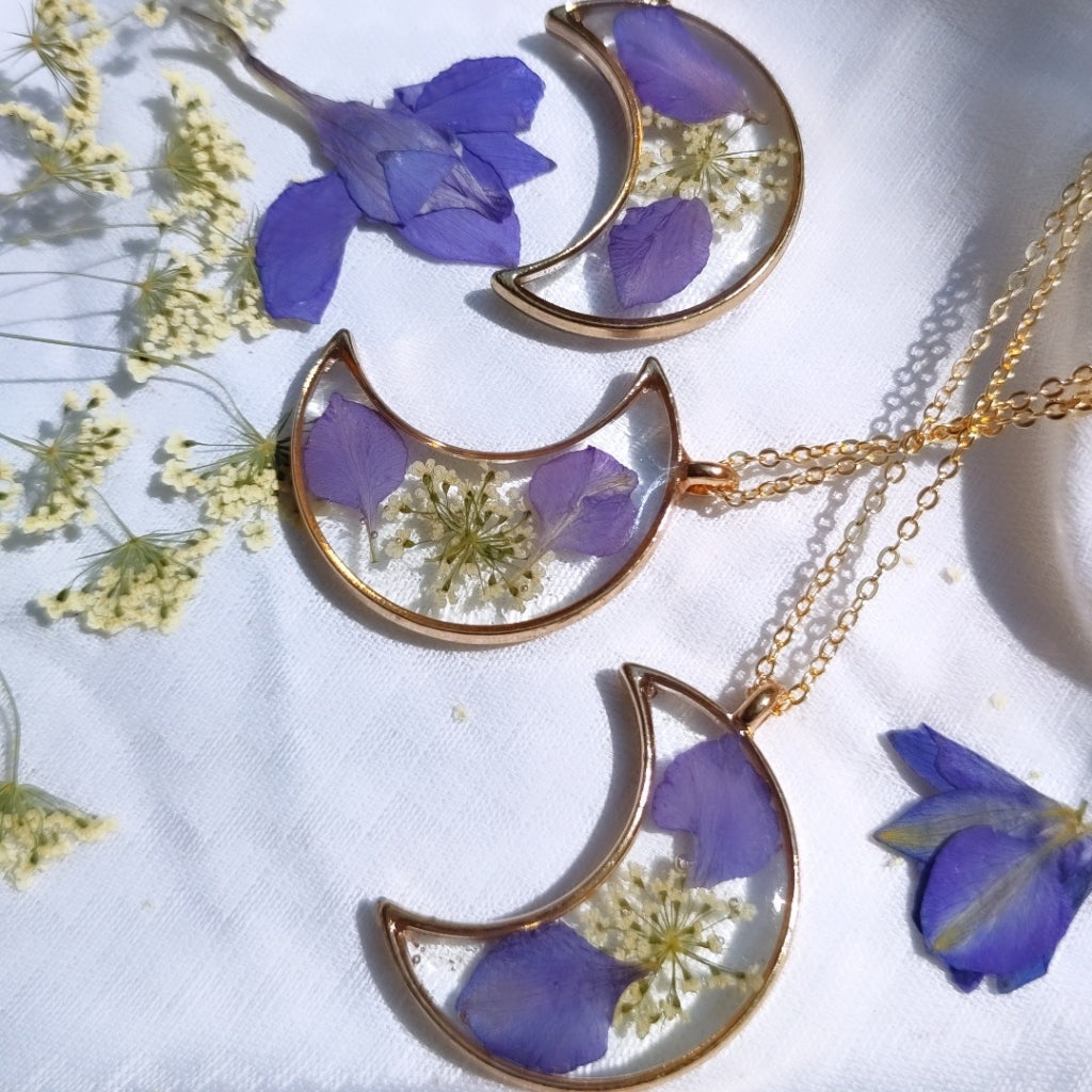 Elegant handcrafted moon-inspired resin necklace featuring delicate preserved blossoms