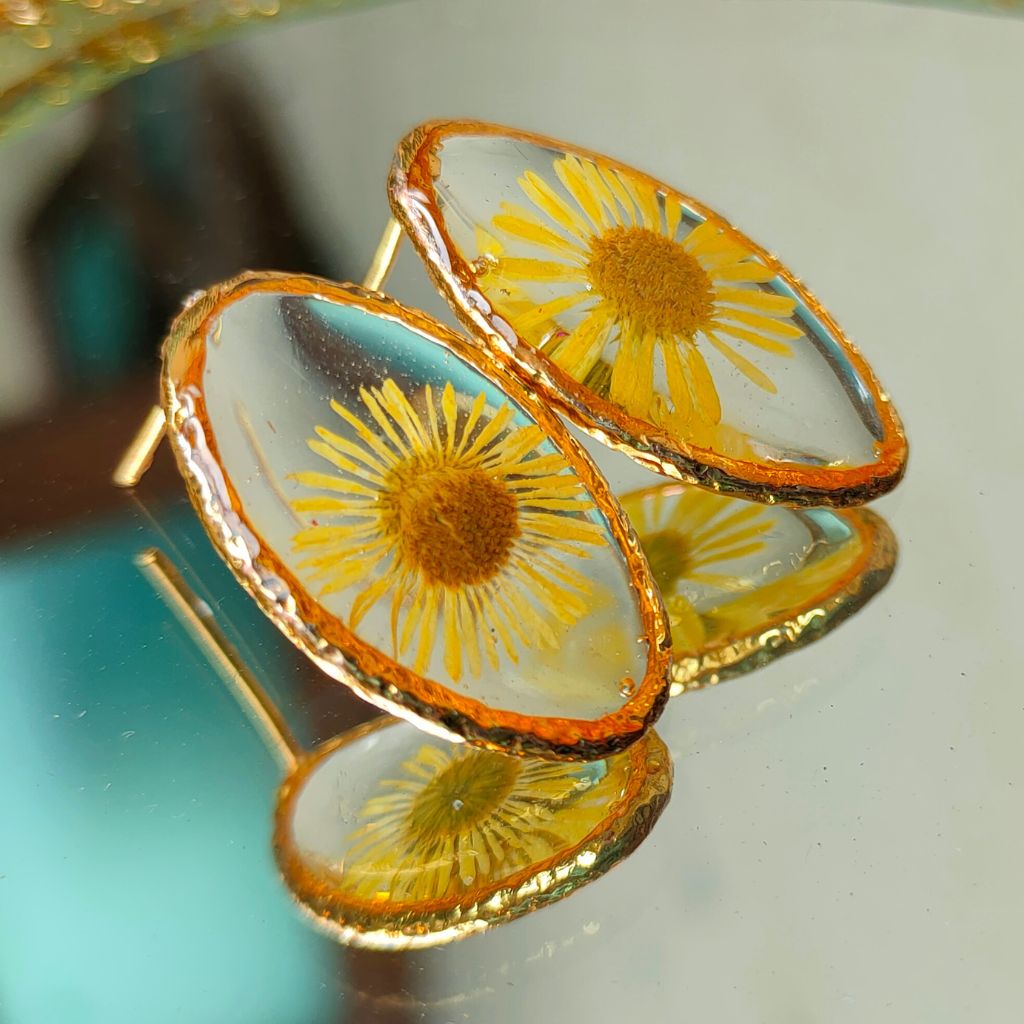 Close-up of Embracing The Dawn resin studs showing delicate preserved floral detailing