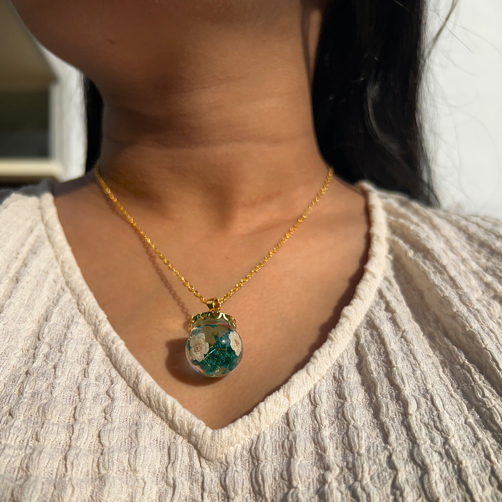 Woman wearing Boscage Tangle real dried foliage resin necklace around her neck showcasing earthy elegance