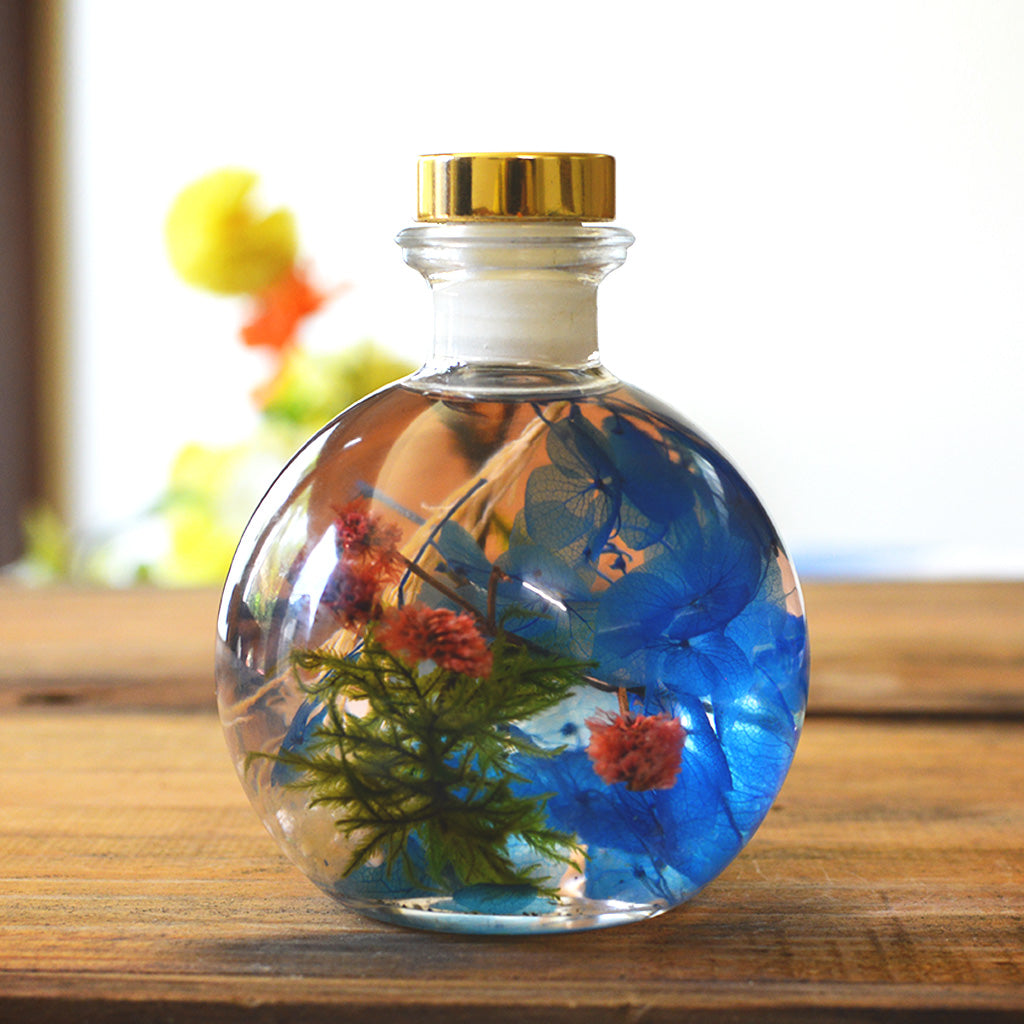 Close-up of Coastal Zephyr Preserved Flower Tabletop by myBageecha – ocean breeze blue preserved blooms. Made with real preserved natural flowers in glass bottle