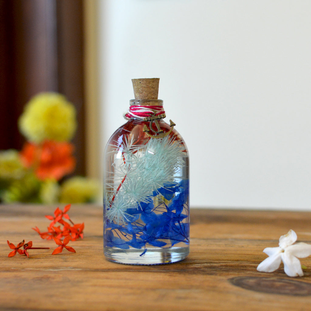 Close-up of Indigo Florescence Preserved Flower Tabletop by myBageecha – deep indigo preserved blooms. Made with natural flowers in glass bottle.
