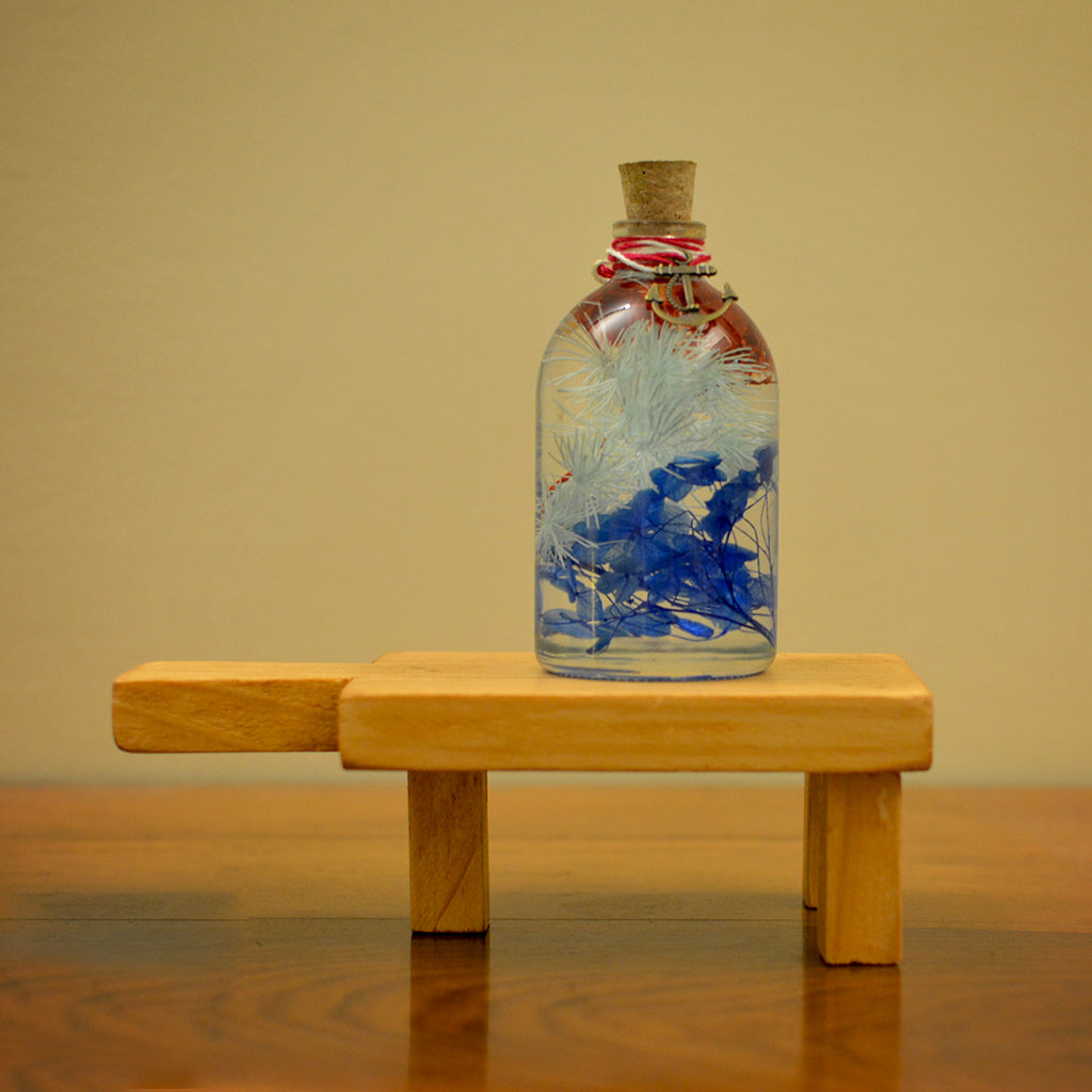 Indigo Florescence Preserved Flower Tabletop on rectangular stand – rich royal-tone preserved arrangement.