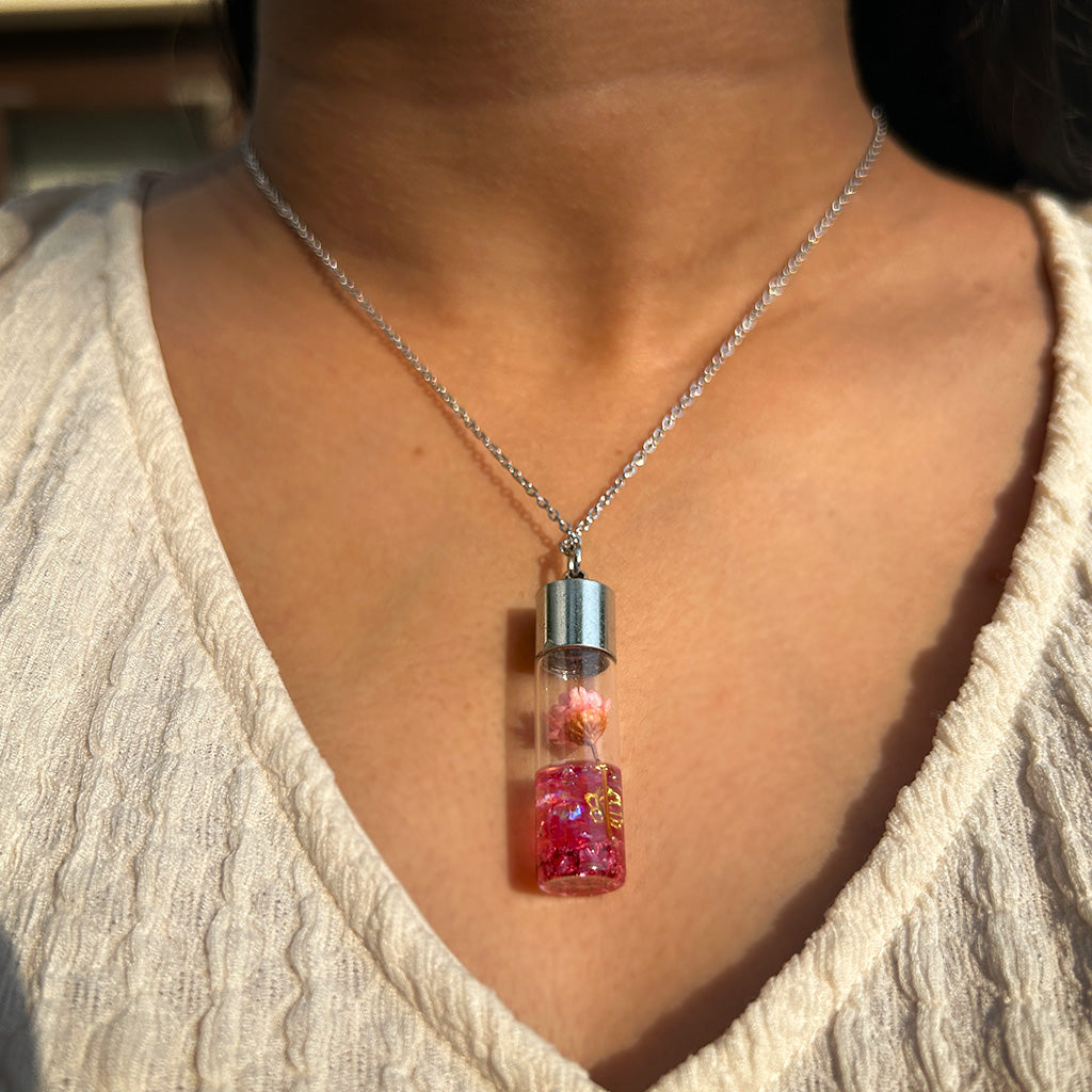Woman wearing Lyrical Lotus real dried flower resin necklace around her neck showcasing natural elegance
