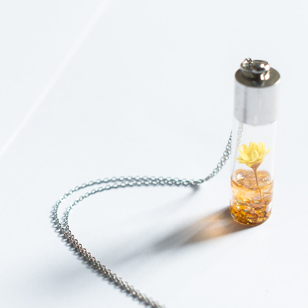 Yellow Lyrical Lotus resin pendant with real dried flower suspended on fine metal chain