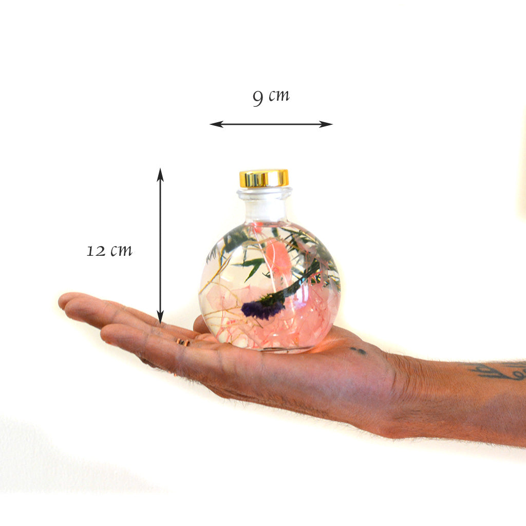 Swirling Salmon Preserved Flower Tabletop shown in hand – warm and graceful preserved décor.