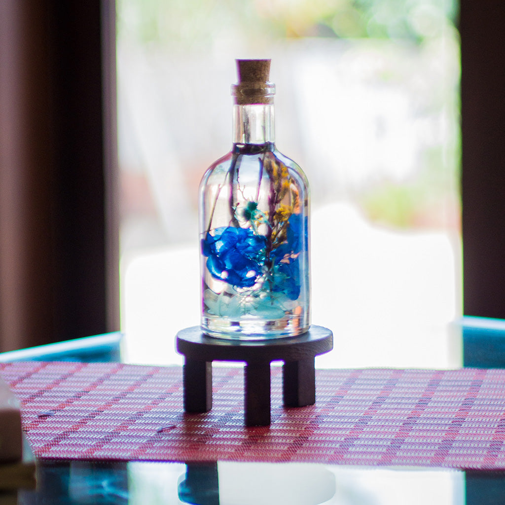 A Big Splash Preserved Flower Tabletop on circular stand – energetic blue décor centerpiece.