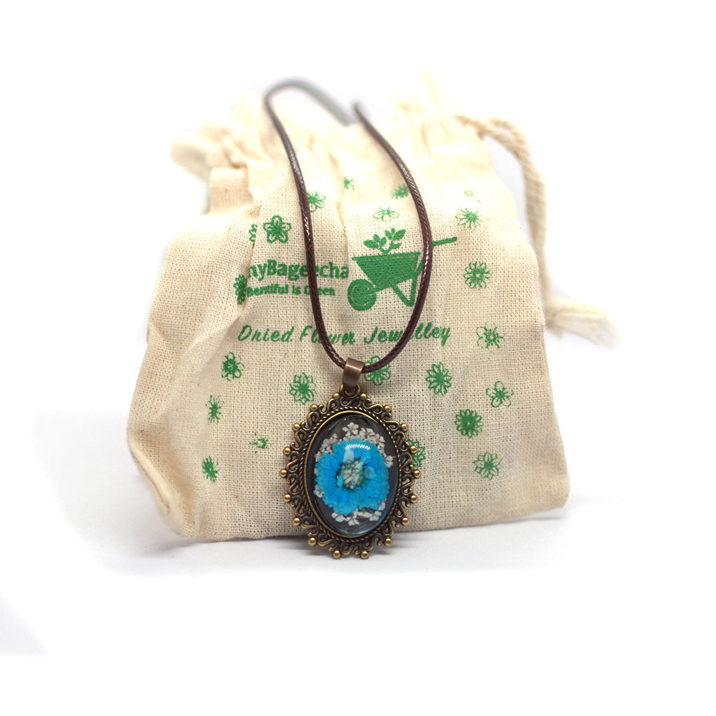 Elegant handcrafted resin necklace featuring delicate blue preserved blooms