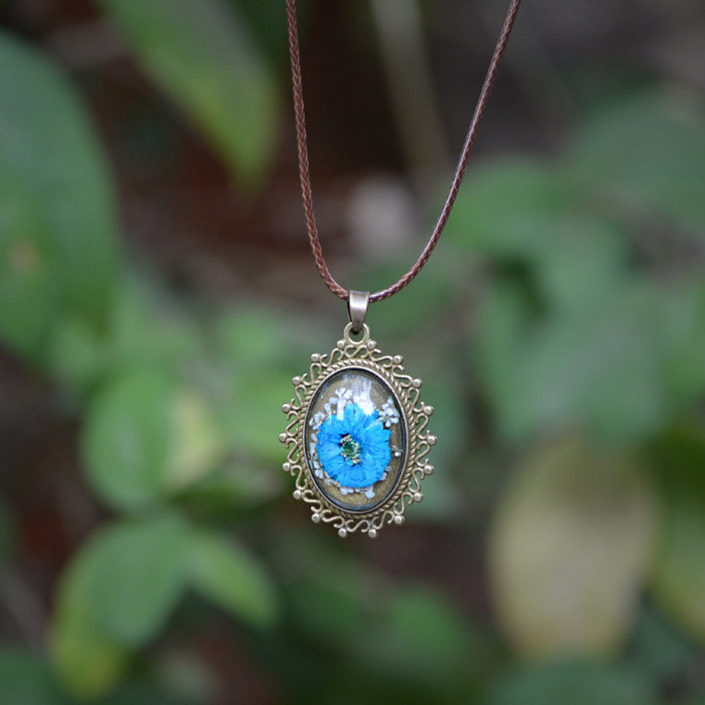 Azure Fantasia necklace with real blue dried flowers preserved in clear resin pendant