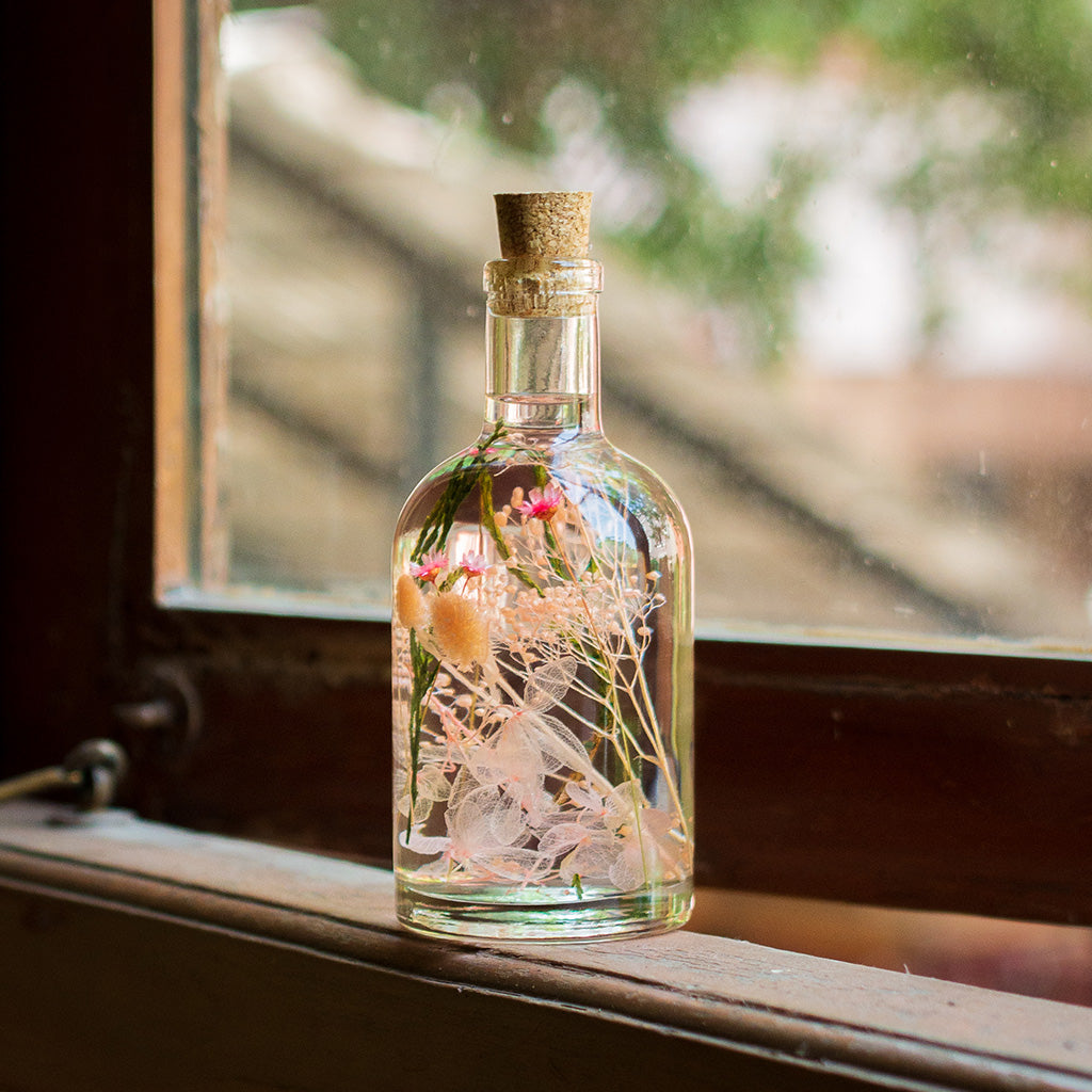 A delicate, romantic preserved arrangement in graceful ballet blush tones.