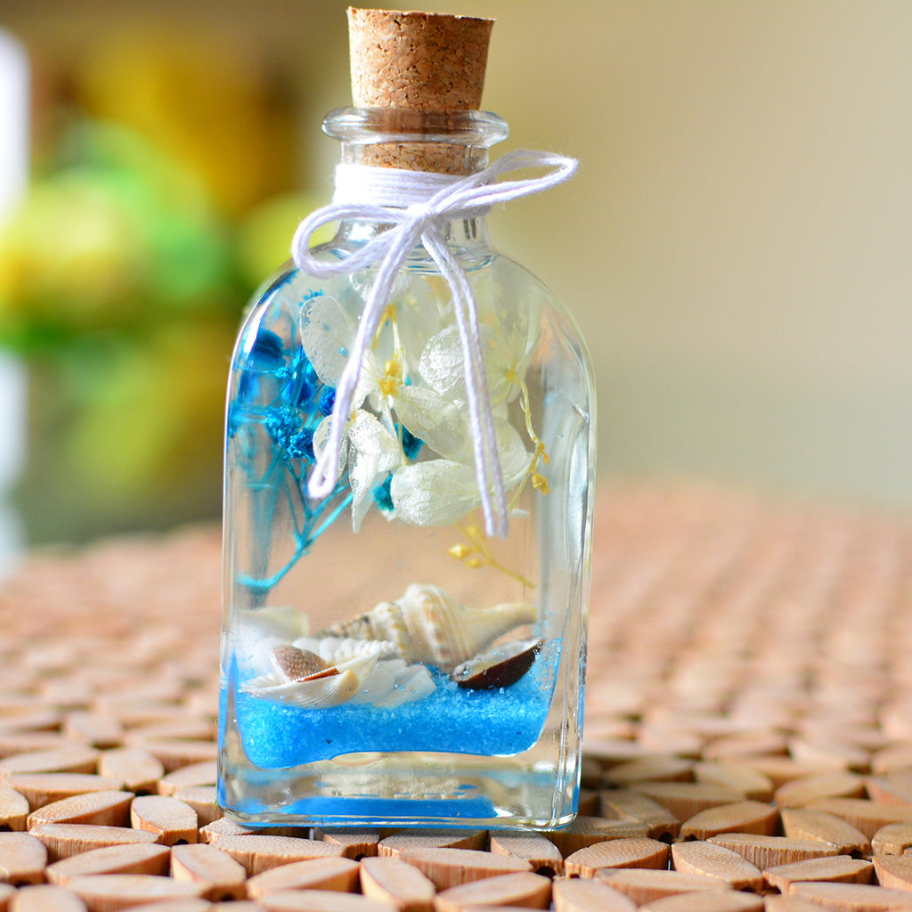 A coastal preserved arrangement evoking calm waves and horizon light.