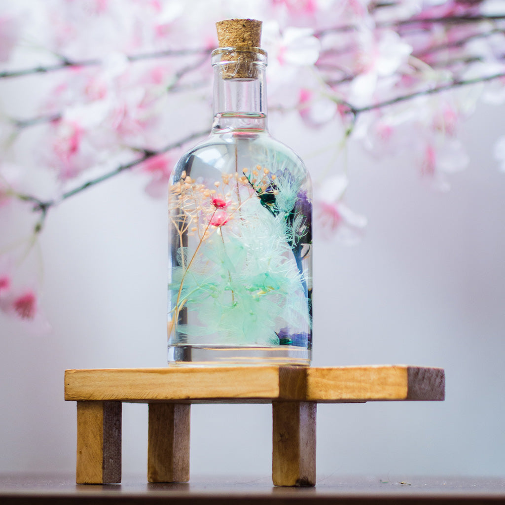 Frolicking Blues Preserved Flower Tabletop on rectangular stand – cheerful blue floral arrangement.