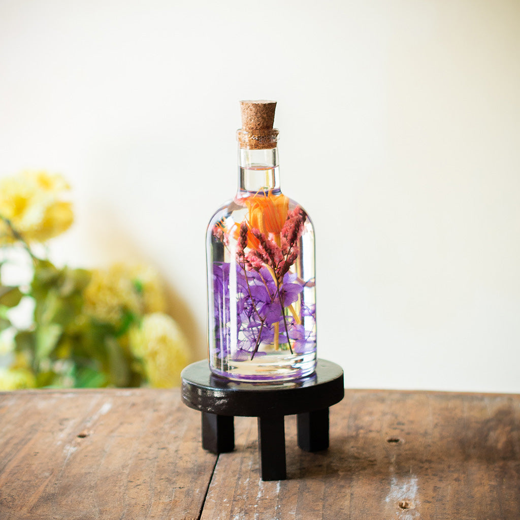 Tumultuous Tints Preserved Flower Tabletop on circular stand – cheerful decorative centerpiece.