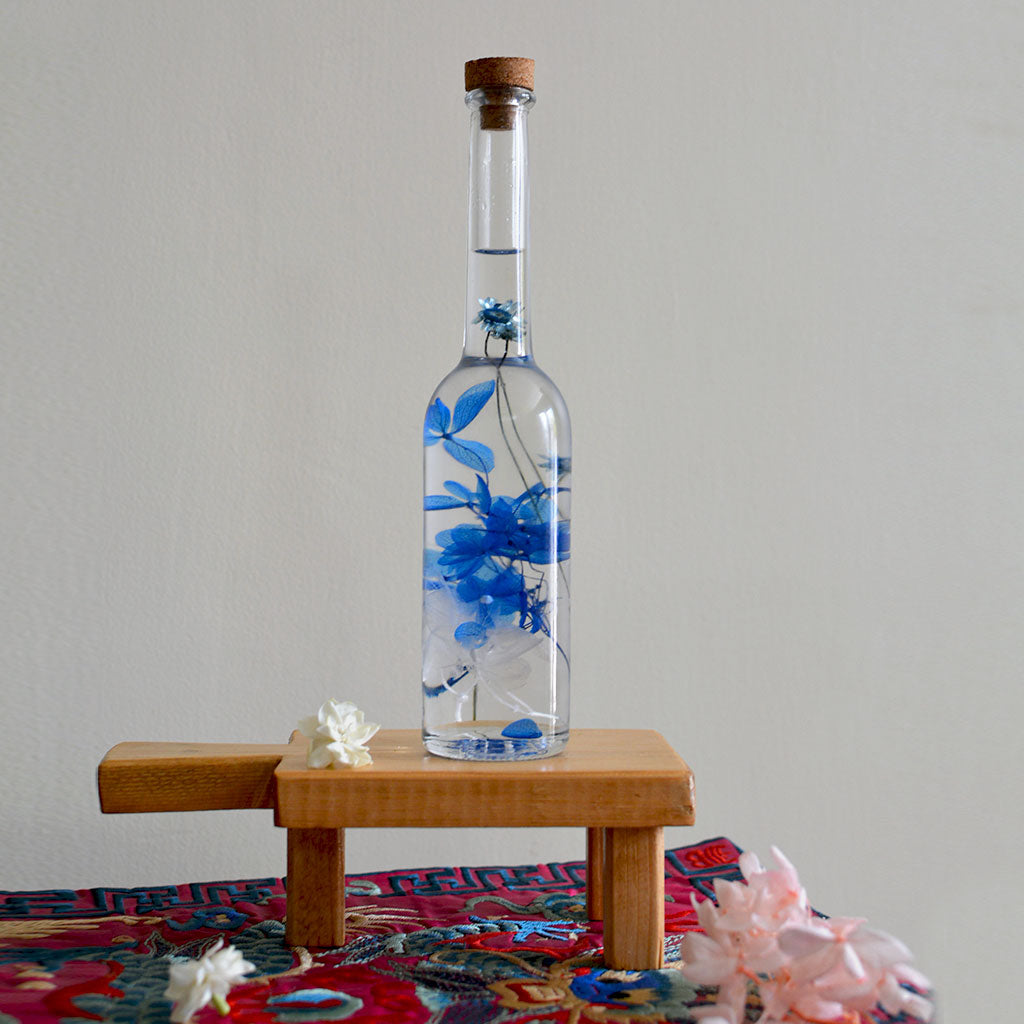 Unfurled Camo Preserved Flower Tabletop on rectangular stand – deep forest aesthetic.