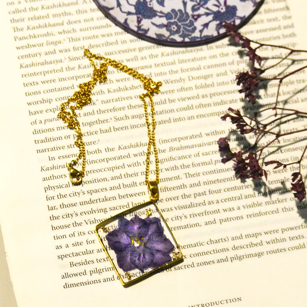 Elegant handcrafted resin necklace featuring real purple preserved blooms with silver bezel