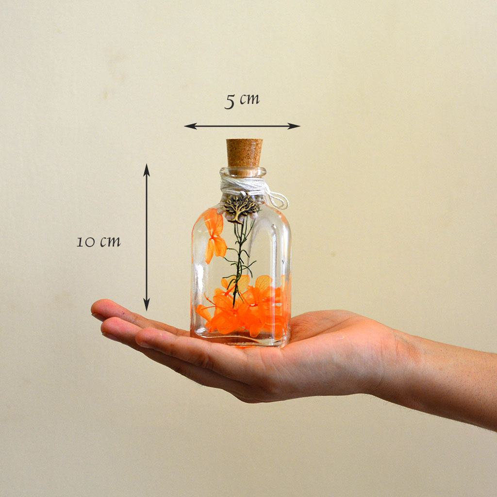 Tangerine Beaut Preserved Flower Tabletop shown in hand – lively décor accent.