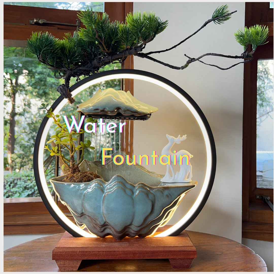 Decorative tabletop water fountain with bonsai plant, deer figurine, and illuminated circular frame for indoor décor