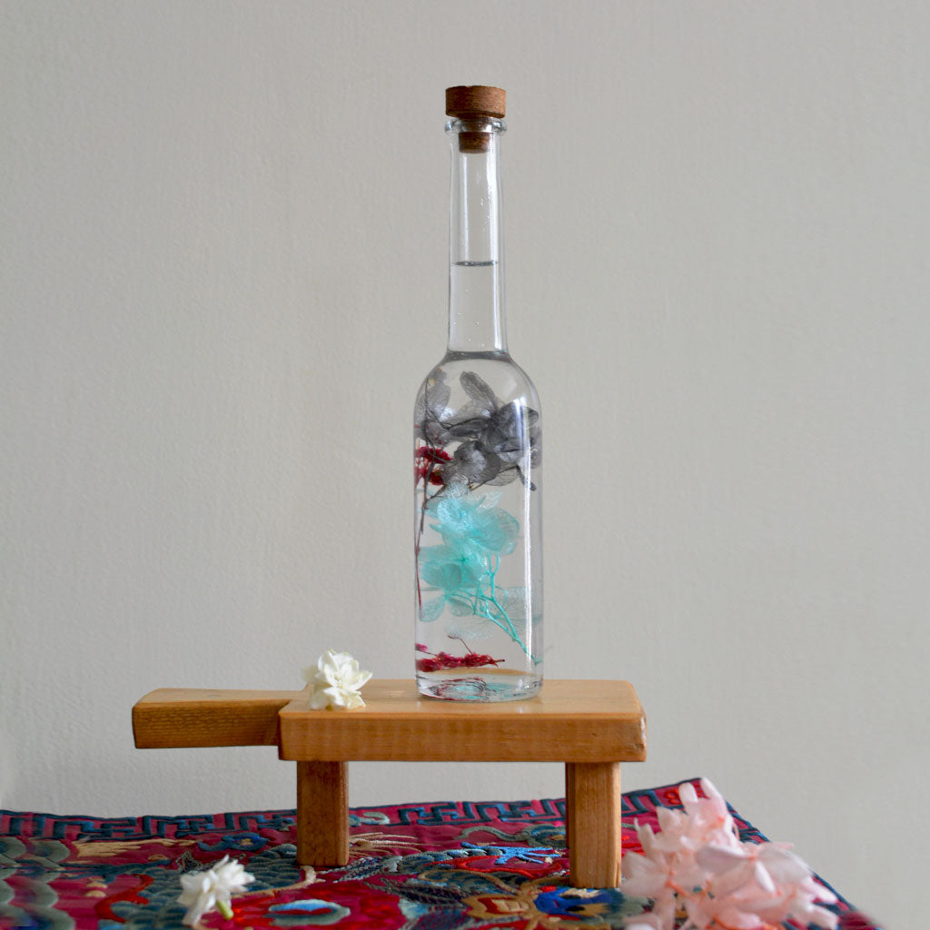 Diablerie Stir Preserved Flower Tabletop on rectangular stand – dramatic preserved display.